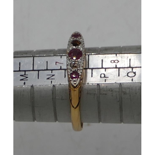 569 - An 18ct gold boat shaped ring set 3 rubies and interspersed by small diamonds (1 diamond missing), s... 