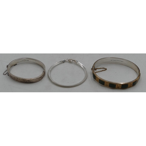 576 - A silver hinged bangle, another silver hinged bangle and a silver bracelet. (3)