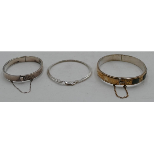 576 - A silver hinged bangle, another silver hinged bangle and a silver bracelet. (3)