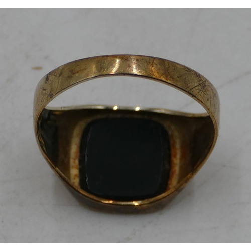 583 - A 9ct gold gentleman's signet ring set with black stone, size S/T, 2.2 grams gross.