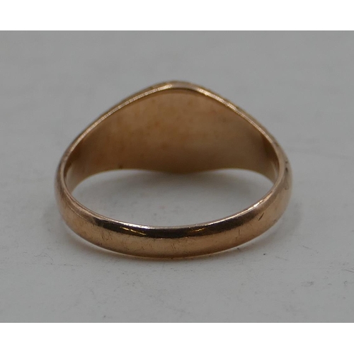 584 - A 9ct gold ring set with cabochon red stone with chased decoration, size O, 3.4 grams.