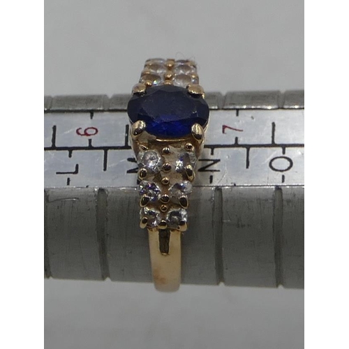 586 - A 14ct gold ladies' ring set with centre sapphire, flanked by 12 clear stones, size M/N, 2.9 grams g... 