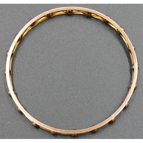 600 - A 9ct gold bangle with ball and pierced decoration, inner measurement 8cm, 17.5 grams.