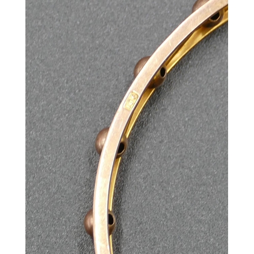 600 - A 9ct gold bangle with ball and pierced decoration, inner measurement 8cm, 17.5 grams.