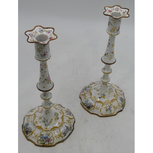 668 - A pair of 18th Century Bilston enamelled candlesticks on white grounds with multi-coloured figure, f... 