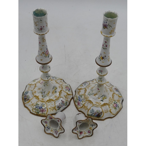 668 - A pair of 18th Century Bilston enamelled candlesticks on white grounds with multi-coloured figure, f... 