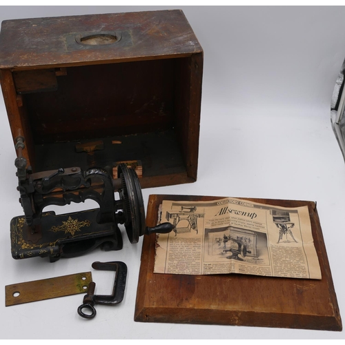 724 - A small early sewing machine (base missing), 20cm high, boxed.