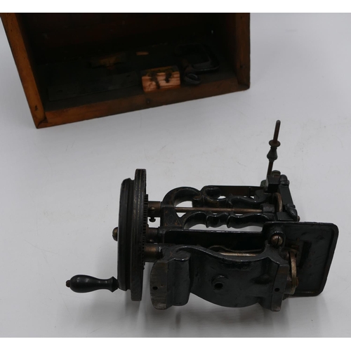 724 - A small early sewing machine (base missing), 20cm high, boxed.