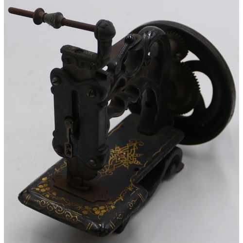 724 - A small early sewing machine (base missing), 20cm high, boxed.