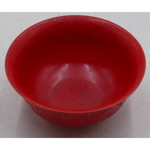 74 - An Oriental red round trumpet shaped bowl with raised dragon decoration, 15.8cm diameter.