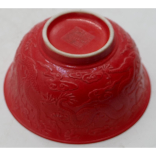 74 - An Oriental red round trumpet shaped bowl with raised dragon decoration, 15.8cm diameter.