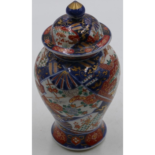 80 - An Imari round bulbous thin necked lidded vase on white, red and blue ground with allover bird, flor... 