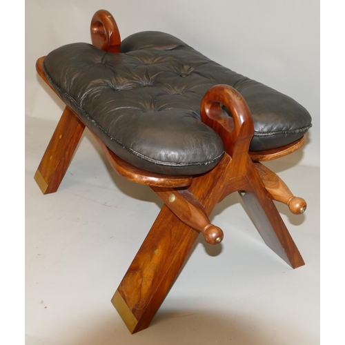 871 - An Eatsern hard wood camel stool with inlaid brass decoration, black leather studded seat, 77cm long... 