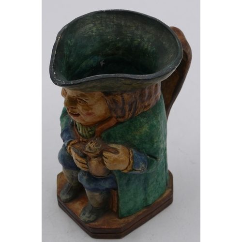 89 - A Compton pottery Toby jug in form of a seated gentleman wearing a green coat holding a jug, 18.7cm ... 