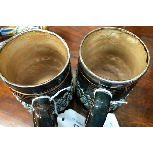 17 - A pair of 19th Century Royal Doulton glazed earthenware tankards with silver rims on green and brown... 