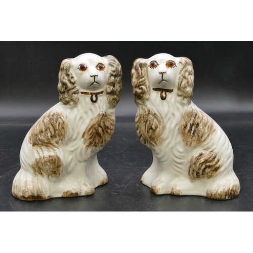 102 - A pair of 19th Century Staffordshire figures of seated spaniels with glass eyes, on white and brown ... 