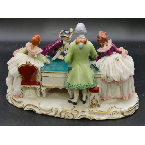 110 - A Naples porcelain group of 4 figures standing around a table, on scallop shaped base, 29.5cm long, ... 