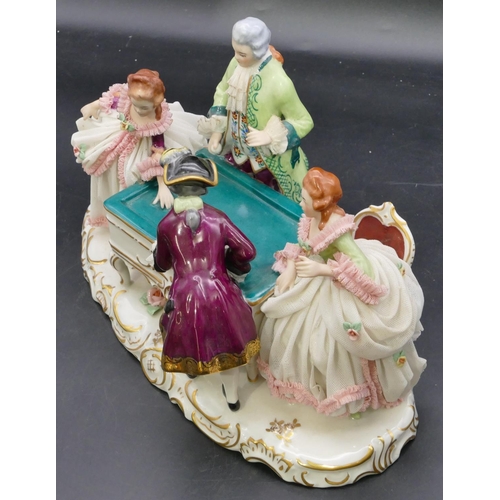 110 - A Naples porcelain group of 4 figures standing around a table, on scallop shaped base, 29.5cm long, ... 