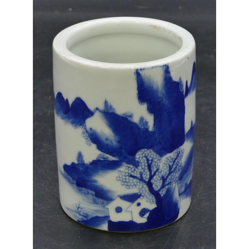 122 - An Oriental cylindrical blue and white brush pot with landscape decoration, 11cm high.