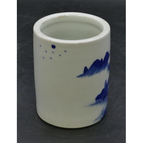 122 - An Oriental cylindrical blue and white brush pot with landscape decoration, 11cm high.