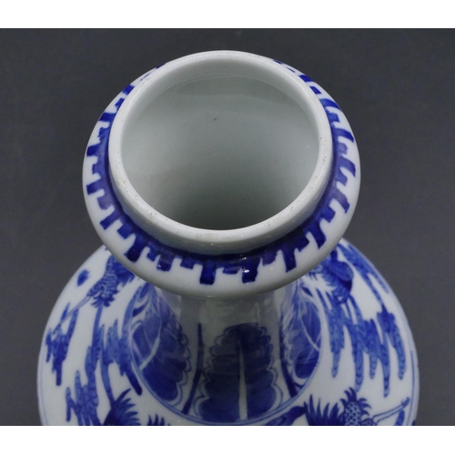 124 - An Oriental round bulbous thin necked trumpet shaped vase on blue and white ground with dragon and p... 