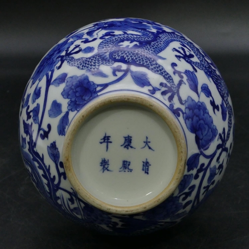 124 - An Oriental round bulbous thin necked trumpet shaped vase on blue and white ground with dragon and p... 