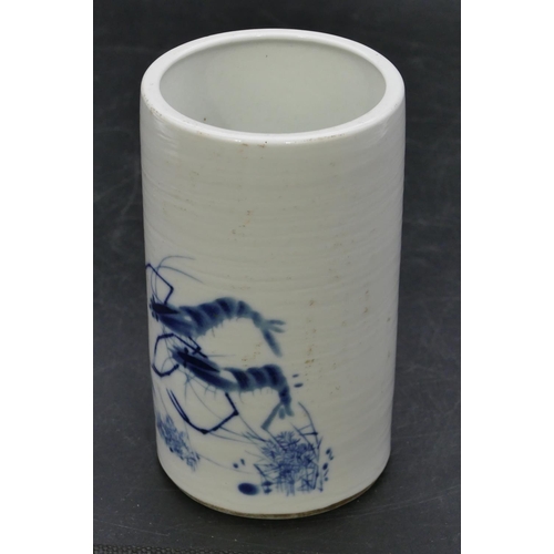 126 - An Oriental cylindrical brush pot on blue and white ground with shrimp decoration, 14cm high.