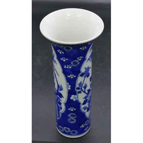 127 - An Oriental cylindrical trumpet shaped vase on blue and white ground with panels of birds, branch an... 