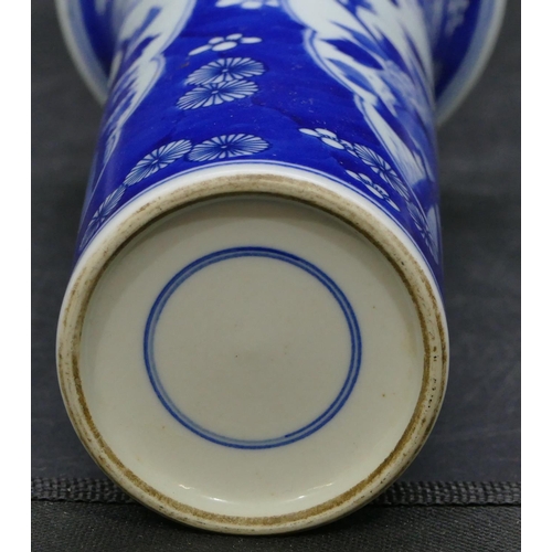 127 - An Oriental cylindrical trumpet shaped vase on blue and white ground with panels of birds, branch an... 