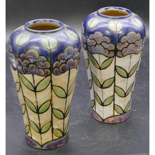 138 - A pair of Royal Doulton glazed earthenware round bulbous shaped vases on multi-coloured ground with ... 