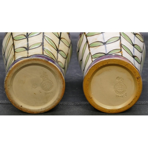 138 - A pair of Royal Doulton glazed earthenware round bulbous shaped vases on multi-coloured ground with ... 