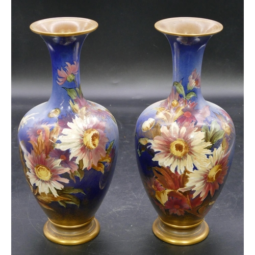 139 - A pair of Doulton & Lambeth round bulbous thin necked trumpet shaped vases on blue ground with multi... 