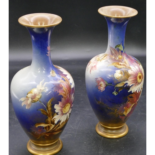 139 - A pair of Doulton & Lambeth round bulbous thin necked trumpet shaped vases on blue ground with multi... 