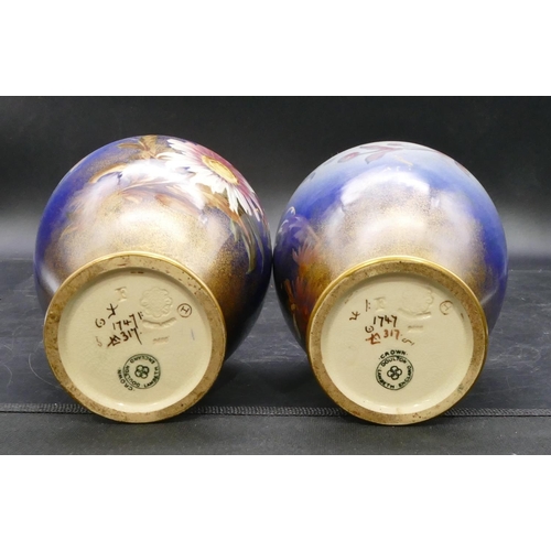 139 - A pair of Doulton & Lambeth round bulbous thin necked trumpet shaped vases on blue ground with multi... 