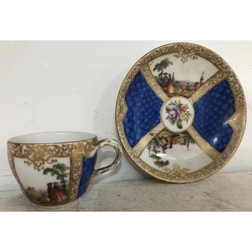 141 - A Meissen style cup and saucer on white and blue ground with hand painted figure, landscape and gilt... 