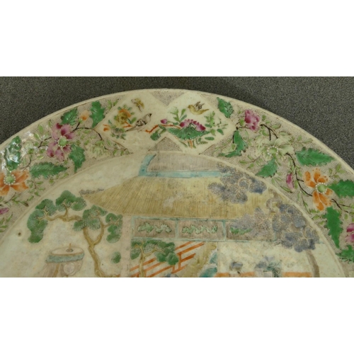 144 - A 19th Century Oriental charger with multi-coloured figure, bird, floral, leaf and scroll decoration... 