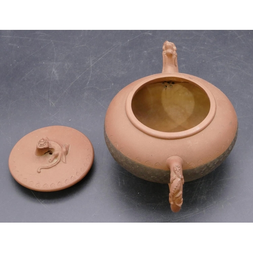 145 - A Chinese terracotta round bulbous shaped teapot with animal finial, 20cm long overall, 10cm high.