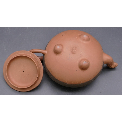 145 - A Chinese terracotta round bulbous shaped teapot with animal finial, 20cm long overall, 10cm high.