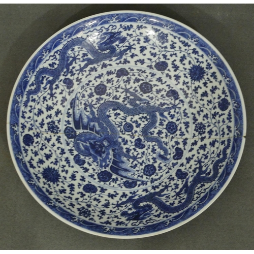 149 - A Chinese 18/19th Century Qianlong blue and white large charger with an allover dragon, floral, leaf...