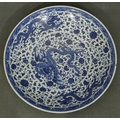 A Chinese 18/19th Century Qianlong blue and white large charger with an allover dragon, floral, leaf... 