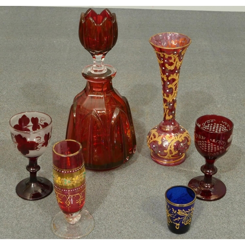 154 - A ruby glass round bulbous thin necked decanter with stopper mounted with shot glass (chip to inner ... 