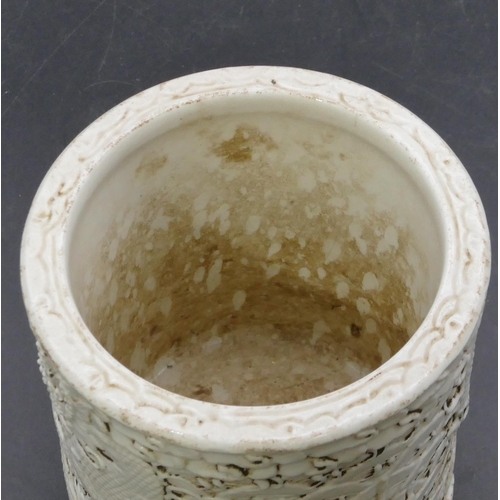 174 - An Oriental cylindrical brush pot on white ground with raised dragon and fish decoration, 11.6cm hig... 