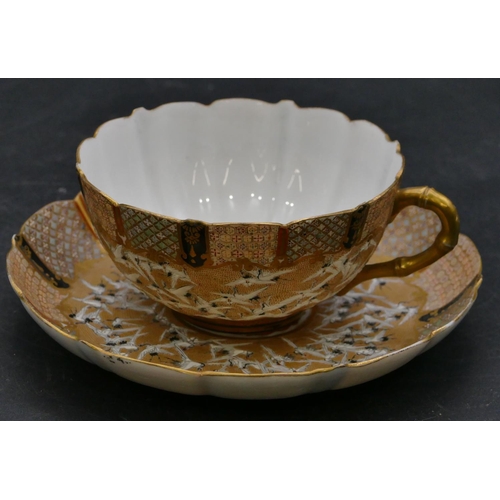 183 - A signed Japanese tea cup and saucer with all over white bird, floral and gilt decoration.