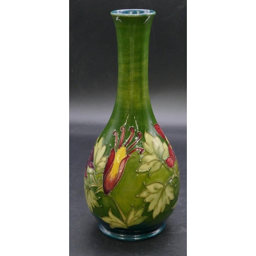 186 - A Moorcroft round bulbous thin necked vase on green ground with multi-coloured floral and leaf decor... 