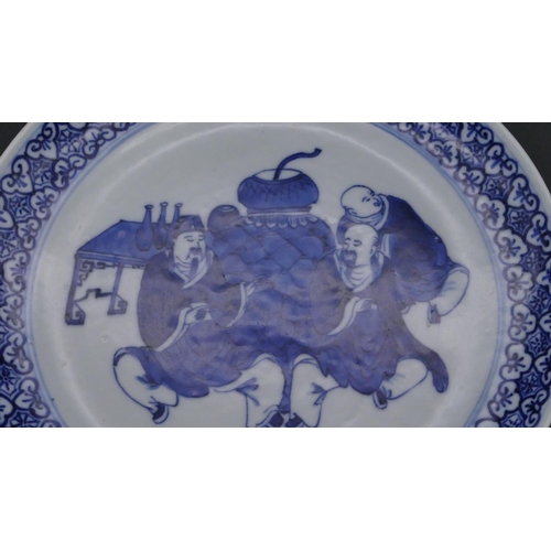 198 - A 19th Century Chinese small round plate on blue and white ground depicting 3 seated figures with sc... 