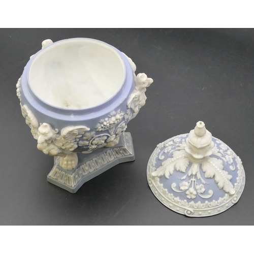 20 - A blue and white Bisque round bulbous lidded pot with raised bird, fruit, floral, leaf and scroll de... 