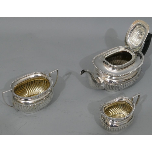 275 - A silver plated 3-piece tea service with half embossed reeded decoration, comprising teapot with ebo... 