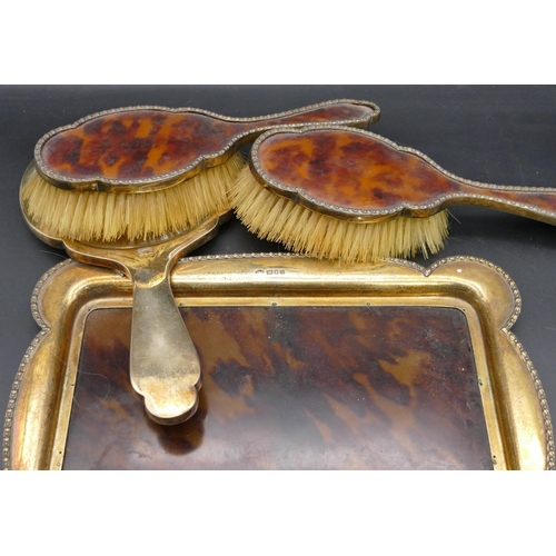 290 - A George V 4-piece silver gilt and tortoiseshell dressing table set comprising rectangular scallop s... 