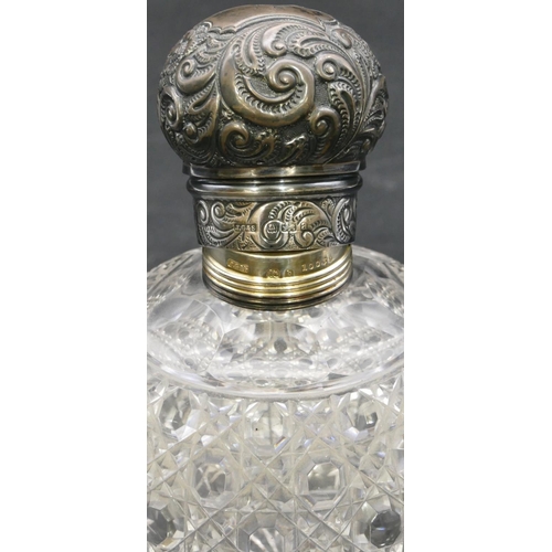 293 - A cut glass round bulbous shaped scent bottle with Birmingham silver screw lid with embossed decorat... 