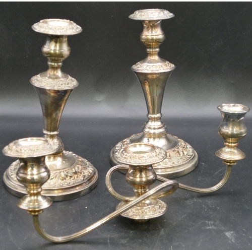 295 - A pair of Sheffield plated candlesticks on turned stems with round sweeping bases, all over embossed... 